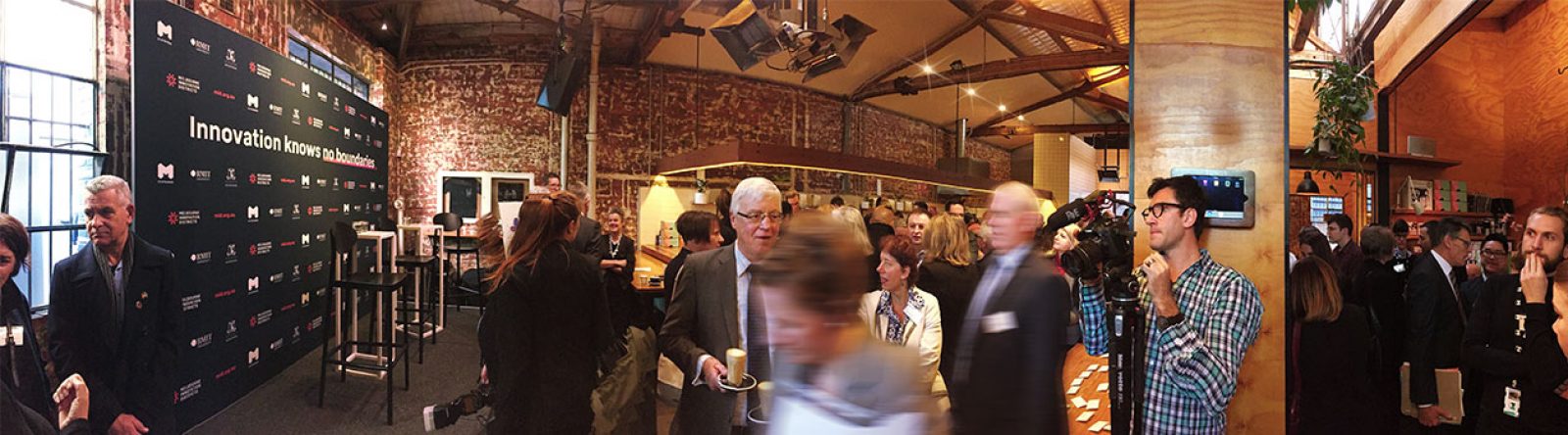 A panoramic view of a launch event space crowded with attendees.