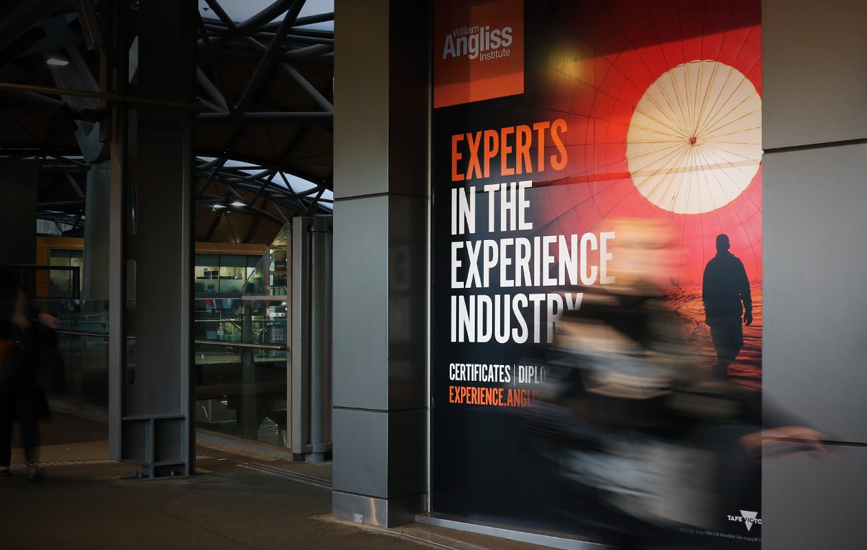 Large scale decal advertising in a train station with tagline "Experts in the Experience Industry"