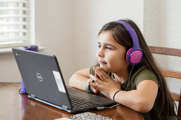 Young girl with computer home schooling